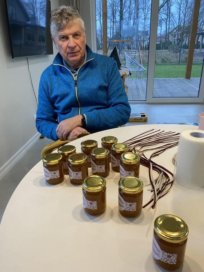 Almants Štelcs gatavojot personalizētās medus dāvanu burciņas