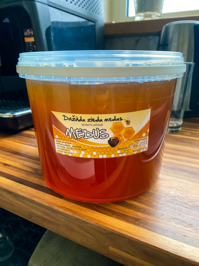 2025. gada vasaras dažādu ziedu medus plastmasas spainītī.