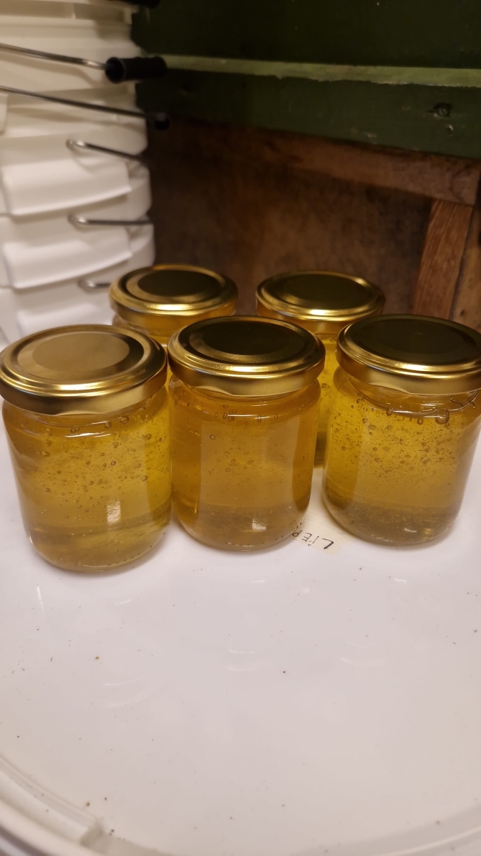 Medus fasēšana stikla burciņās.